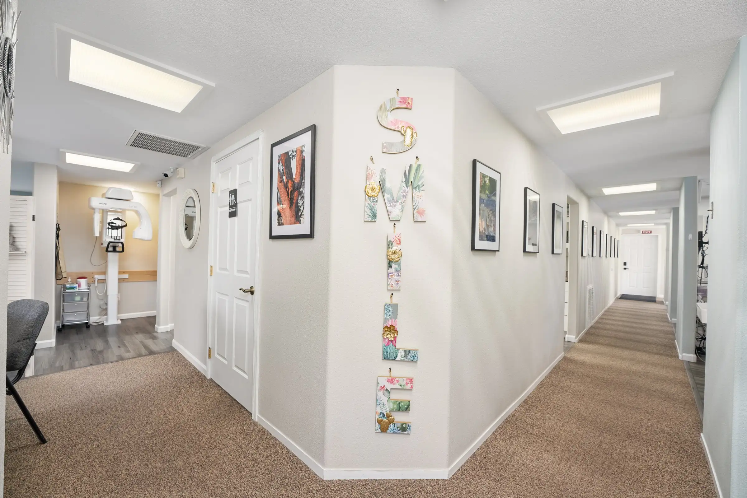The hallway to the treatment rooms, decorated with a SMILE sign and local artwork